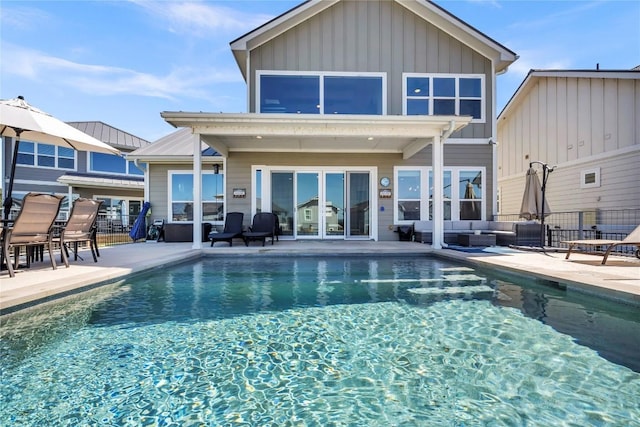 back of house with fence, a patio, an outdoor living space, and an outdoor pool