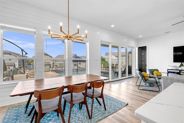 dining room featuring a healthy amount of sunlight, an inviting chandelier, recessed lighting, and wood finished floors