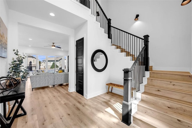 staircase with a ceiling fan, baseboards, recessed lighting, and wood finished floors