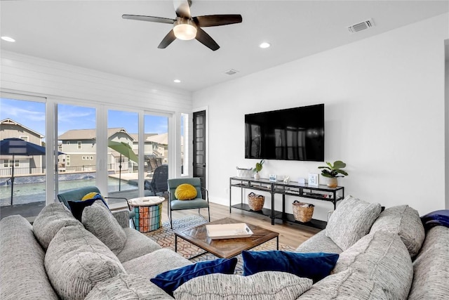 living room featuring a ceiling fan, wood finished floors, recessed lighting, and a residential view