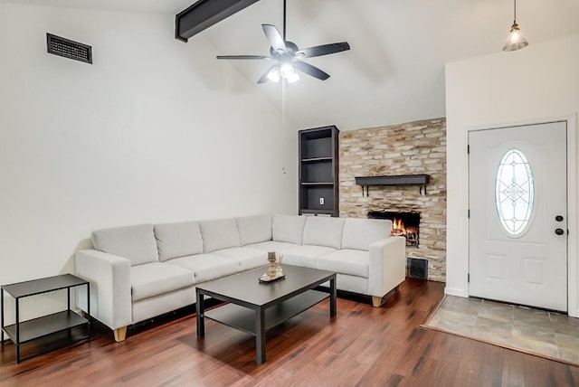 302 Garden Ct, Round Rock, TX 78664 - living room with a stone fireplace, ceiling fan, visible vents, wood finished floors, and beam ceiling