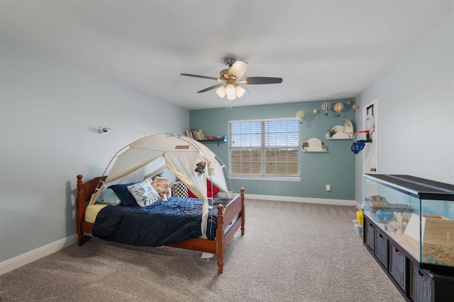 carpeted bedroom with ceiling fan and baseboards