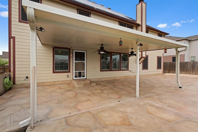 rear view of house featuring a patio, a chimney, fence, and ceiling fan