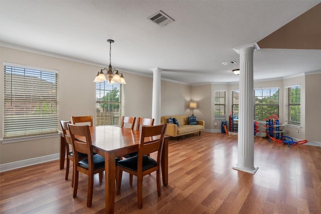 dining space with plenty of natural light, visible vents, baseboards, and ornate columns