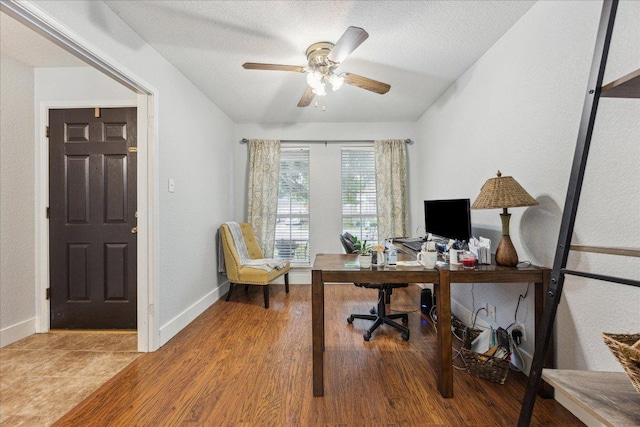 office featuring baseboards, lofted ceiling, ceiling fan, and wood finished floors