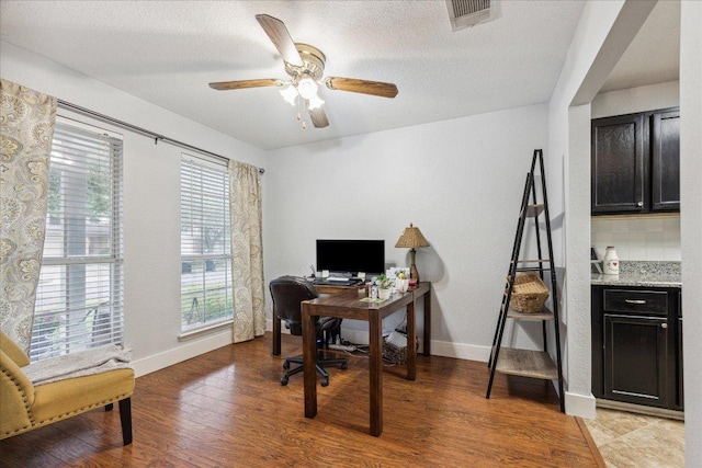 office featuring baseboards, a wealth of natural light, light wood-style flooring, and visible vents