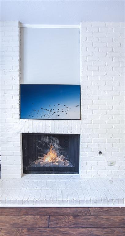 details featuring a fireplace and wood finished floors