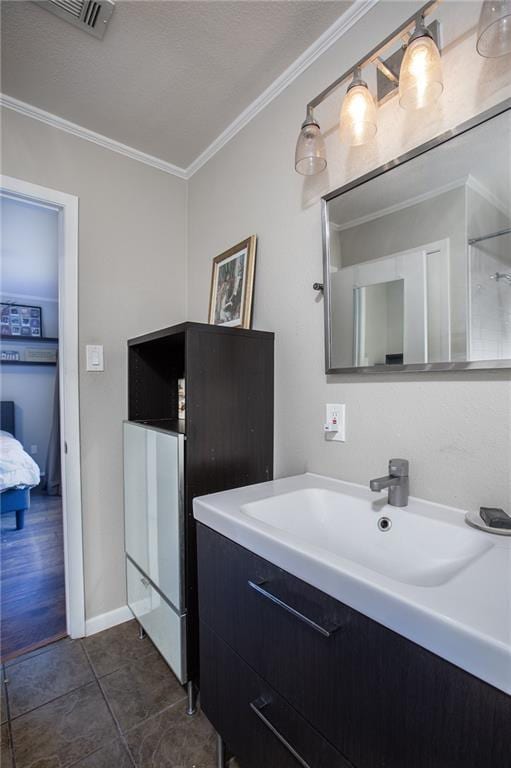 ensuite bathroom with tile patterned floors, ensuite bathroom, visible vents, vanity, and ornamental molding