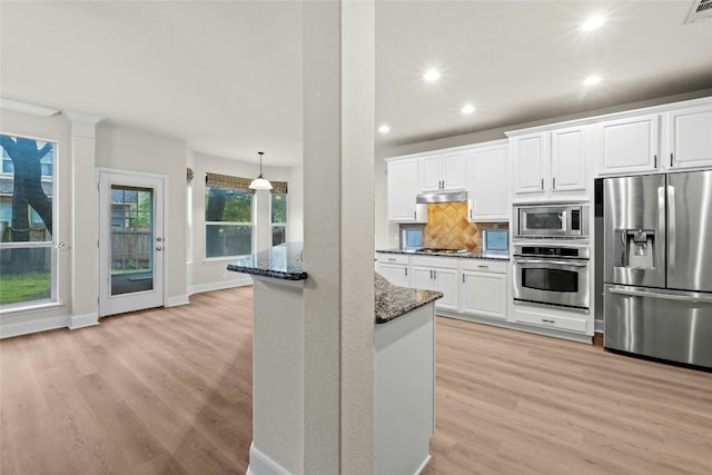 2509 Salorn Way, Round Rock, TX 78681 - kitchen with dark stone counters, appliances with stainless steel finishes, light wood-style flooring, and tasteful backsplash