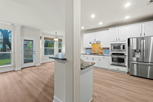 2509 Salorn Way, Round Rock, TX 78681 - kitchen with appliances with stainless steel finishes, dark stone counters, under cabinet range hood, light wood-style floors, and recessed lighting