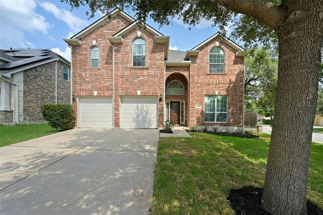 2509 Salorn Way, Round Rock, TX 78681 - traditional home with a garage, concrete driveway, a front yard, and brick siding