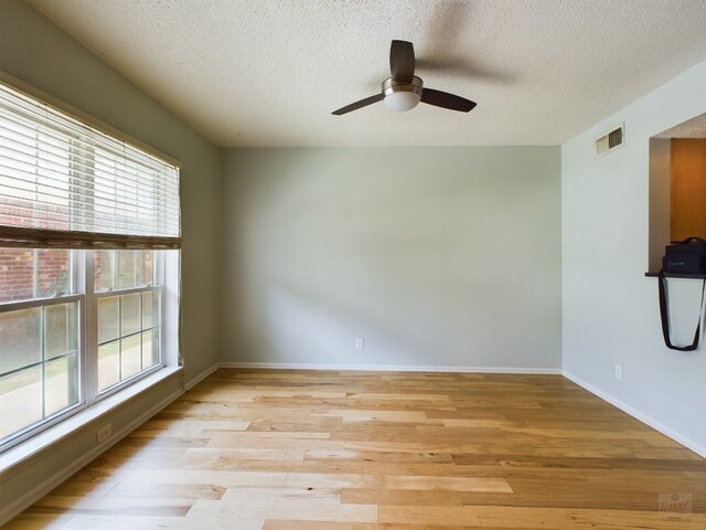 7920 Rockwood Ln Unit 115, Austin, TX 78757 - spare room featuring plenty of natural light, ceiling fan, light wood finished floors, and a textured ceiling