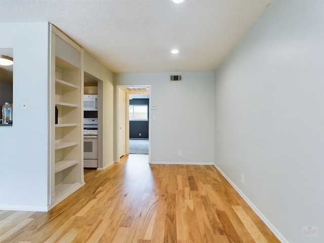 7920 Rockwood Ln Unit 115, Austin, TX 78757 - spare room featuring light wood-style flooring, a textured ceiling, built in shelves, and recessed lighting