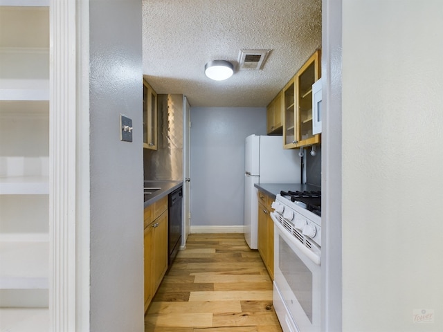 7920 Rockwood Ln Unit 115, Austin, TX 78757 - kitchen with white appliances, light wood finished floors, a textured ceiling, dark countertops, and glass insert cabinets