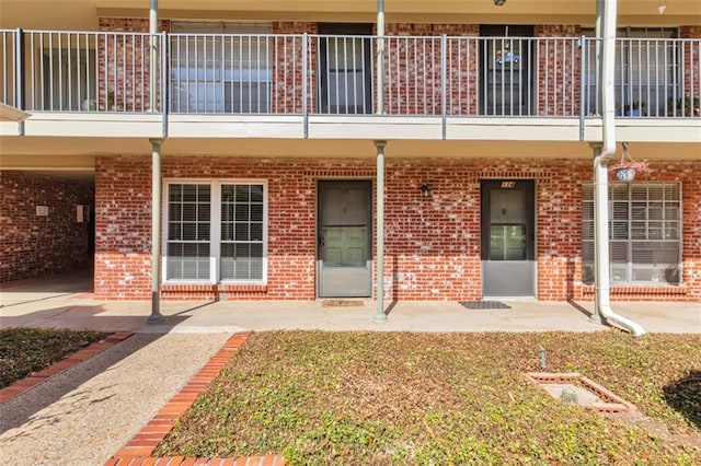 7920 Rockwood Ln Unit 115, Austin, TX 78757 - property entrance with a balcony, brick siding, and a patio area
