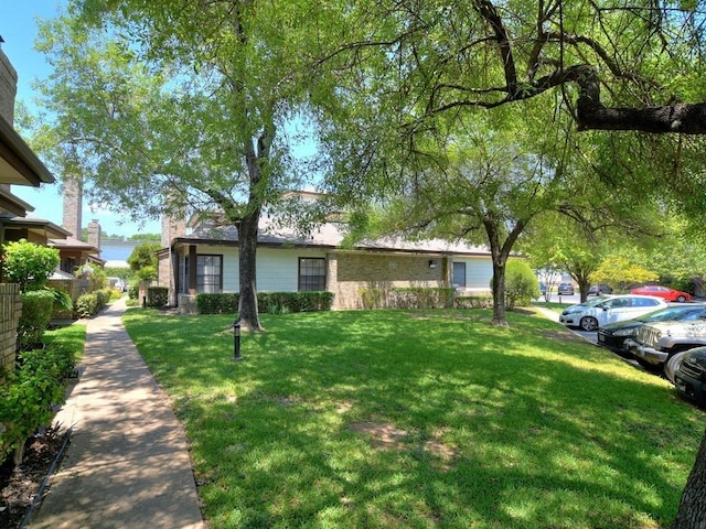 view of front of home featuring uncovered parking, a chimney, and a front yard