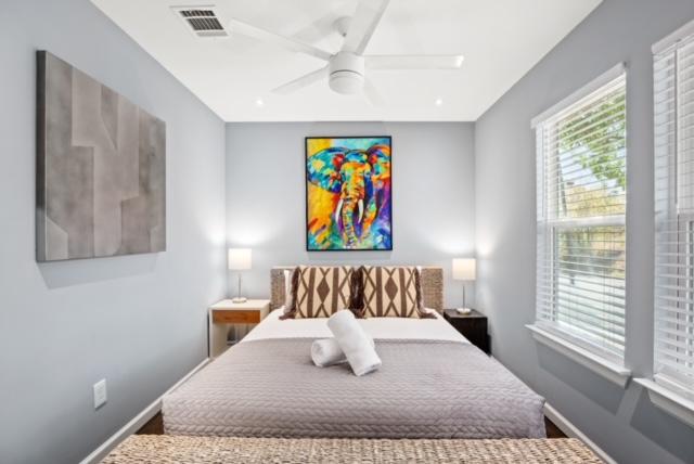 bedroom featuring ceiling fan, baseboards, visible vents, and wood finished floors