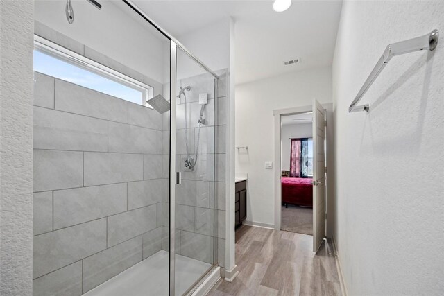 8220 Linnie Ln, Austin, TX 78724 - ensuite bathroom featuring a stall shower, wood finished floors, vanity, and baseboards