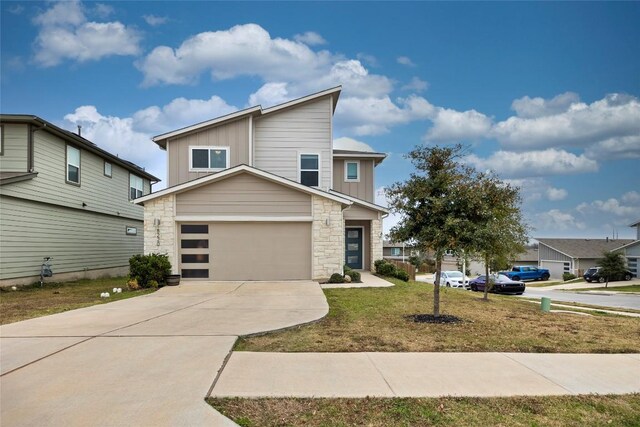 8220 Linnie Ln, Austin, TX 78724 - contemporary home featuring board and batten siding, stone siding, concrete driveway, an attached garage, and a front yard