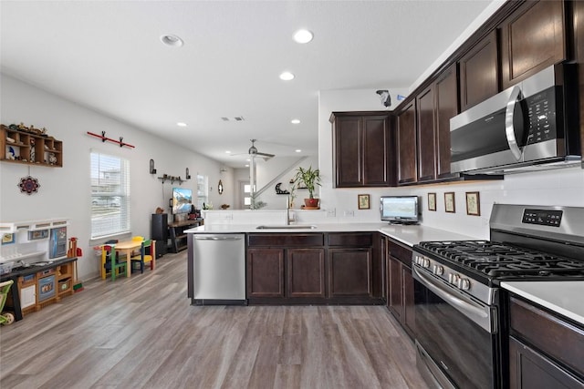 8220 Linnie Ln, Austin, TX 78724 - kitchen with stainless steel appliances, a sink, dark brown cabinetry, light wood-style floors, and ceiling fan