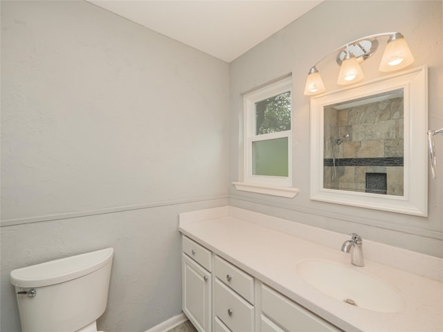 full bath with tiled shower, vanity, and toilet