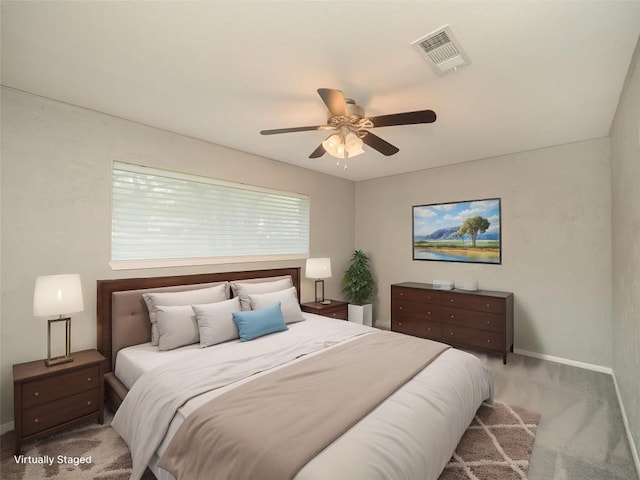 carpeted bedroom with visible vents, baseboards, and a ceiling fan