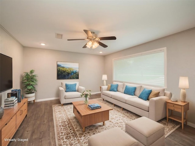 living area featuring baseboards, a ceiling fan, visible vents, and wood finished floors