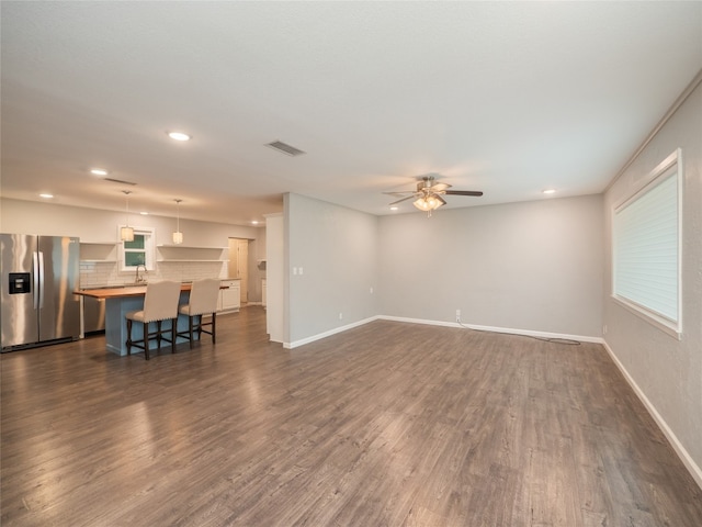 unfurnished living room with a ceiling fan, dark wood-style flooring, recessed lighting, and visible vents