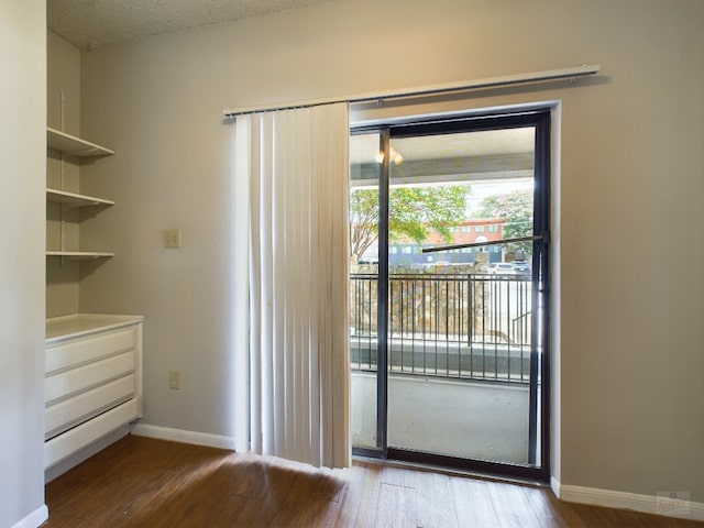 2901 San Jacinto Blvd Unit 105, Austin, TX 78705 - doorway to outside featuring baseboards and wood finished floors