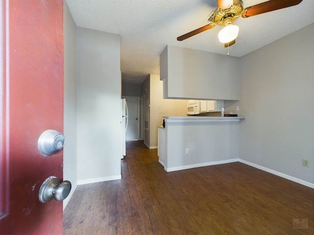 2901 San Jacinto Blvd Unit 105, Austin, TX 78705 - kitchen featuring a ceiling fan, baseboards, white appliances, a peninsula, and wood finished floors