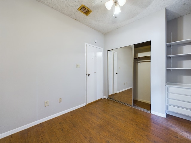2901 San Jacinto Blvd Unit 105, Austin, TX 78705 - unfurnished bedroom featuring wood finished floors, a closet, a textured ceiling, visible vents, and baseboards