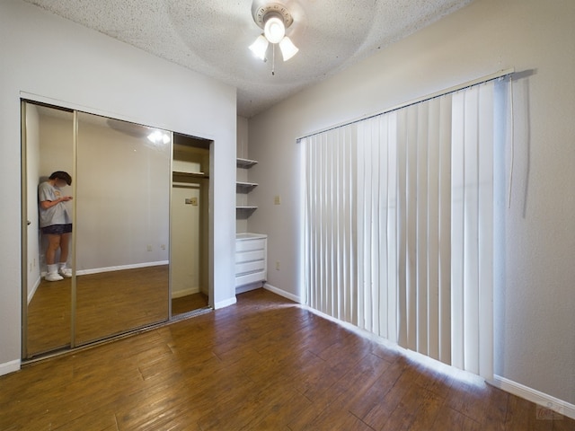 2901 San Jacinto Blvd Unit 105, Austin, TX 78705 - unfurnished bedroom featuring a closet, wood finished floors, a textured ceiling, ceiling fan, and baseboards