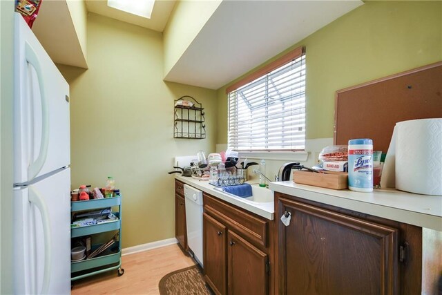 3115 Tom Green St Unit 404, Austin, TX 78705 - kitchen with white appliances, light countertops, light wood-type flooring, and a sink
