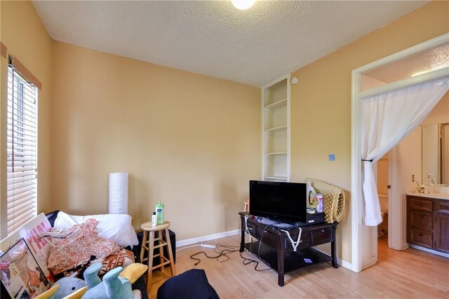 3115 Tom Green St Unit 404, Austin, TX 78705 - bedroom with baseboards, ensuite bathroom, light wood-style flooring, and a textured ceiling