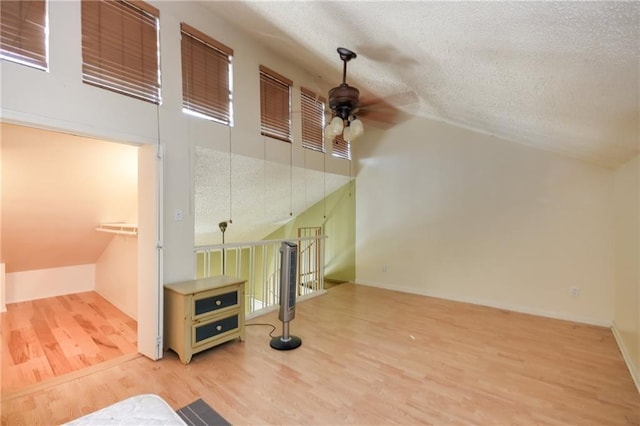 3115 Tom Green St Unit 404, Austin, TX 78705 - unfurnished living room featuring lofted ceiling, a textured ceiling, a ceiling fan, and wood finished floors