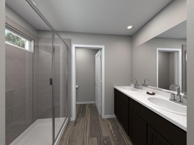 full bathroom with a sink, double vanity, a shower stall, and wood finished floors