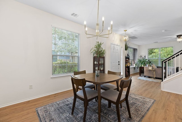 dining space with stairway, light wood-style flooring, baseboards, and visible vents