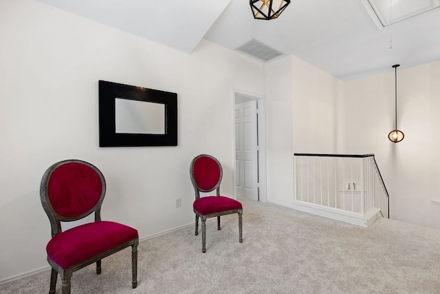 sitting room featuring attic access, visible vents, an upstairs landing, and carpet