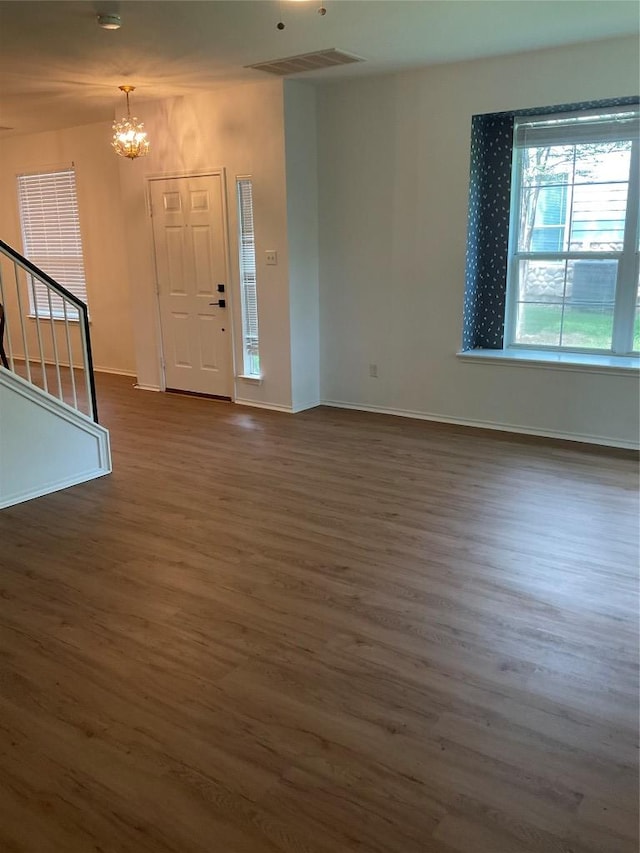 entryway featuring a chandelier, dark wood-type flooring, baseboards, and stairs
