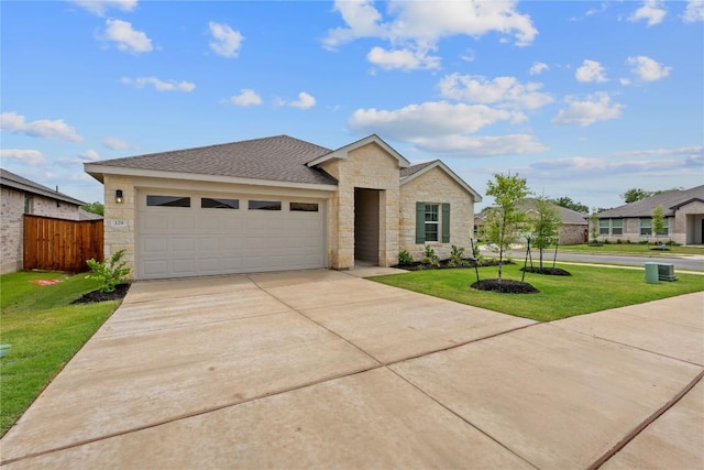 129 Bruin Paw Dr, Georgetown, TX 78628 - ranch-style home with a front yard, a garage, stone siding, and driveway