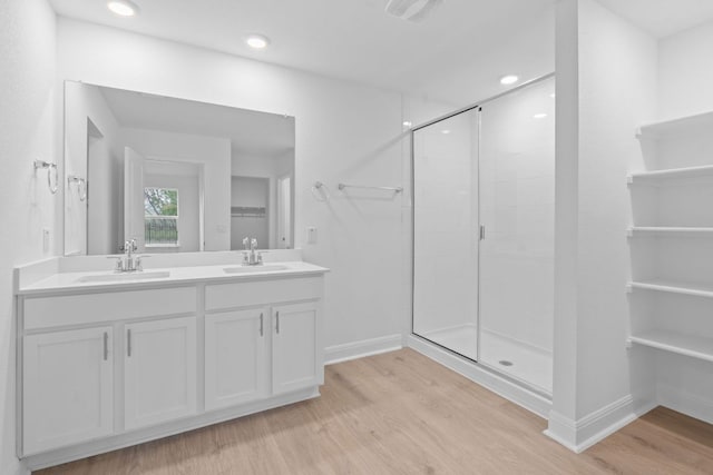 409 Rivers Edge Dr, Georgetown, TX 78628 - full bath featuring a sink, double vanity, a stall shower, and wood finished floors
