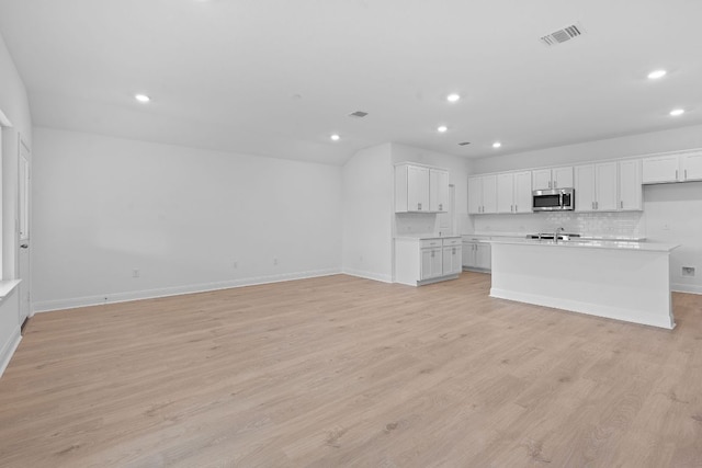 409 Rivers Edge Dr, Georgetown, TX 78628 - kitchen featuring stainless steel microwave, baseboards, visible vents, and recessed lighting