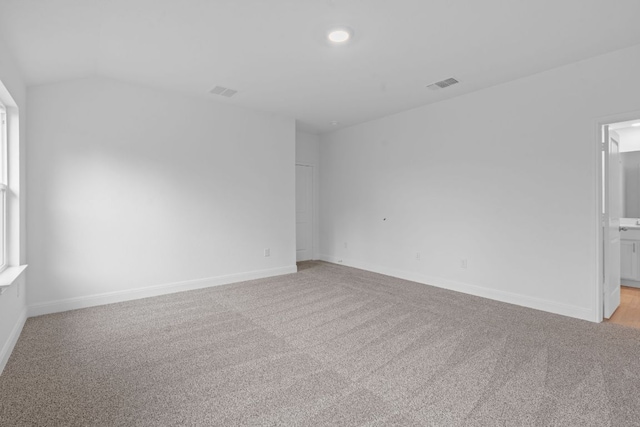 409 Rivers Edge Dr, Georgetown, TX 78628 - spare room featuring vaulted ceiling, light carpet, baseboards, and visible vents