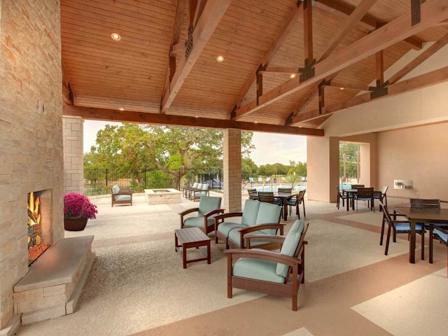 view of patio with an outdoor fire pit, outdoor dining area, and fence