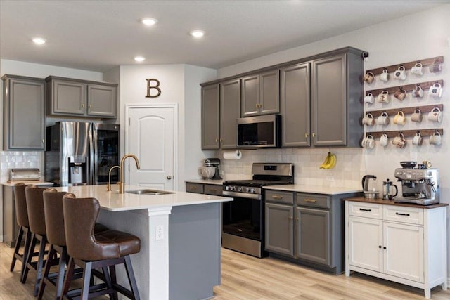 1001 Dog Iron St, Georgetown, TX 78633 - kitchen featuring a sink, light wood-style flooring, backsplash, and appliances with stainless steel finishes