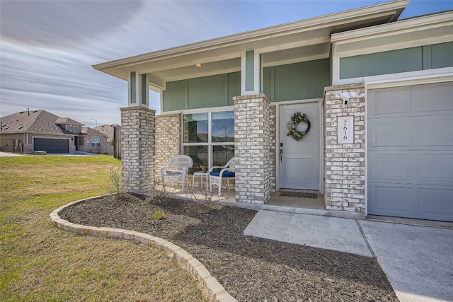 doorway to property with a lawn, a garage, stucco siding, stone siding, and a porch