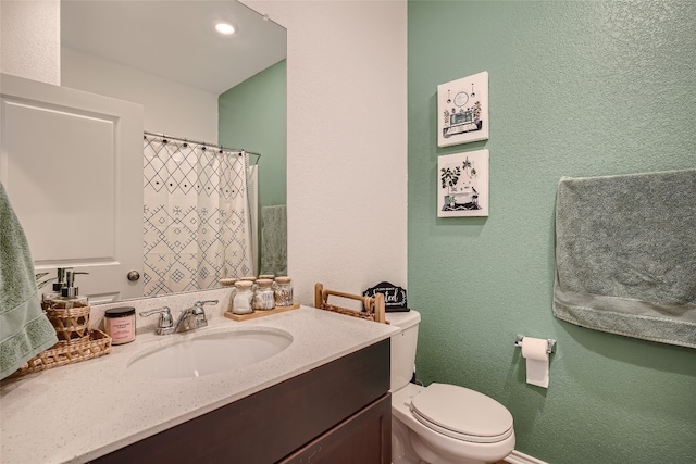 full bathroom featuring vanity, toilet, a textured wall, and a shower with curtain