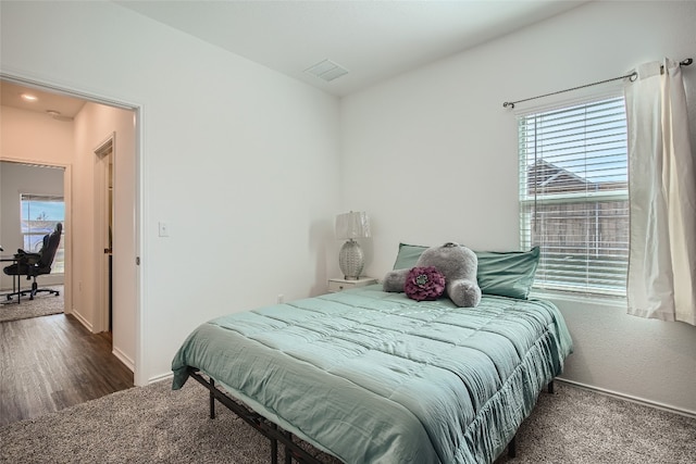 bedroom with carpet, visible vents, and baseboards