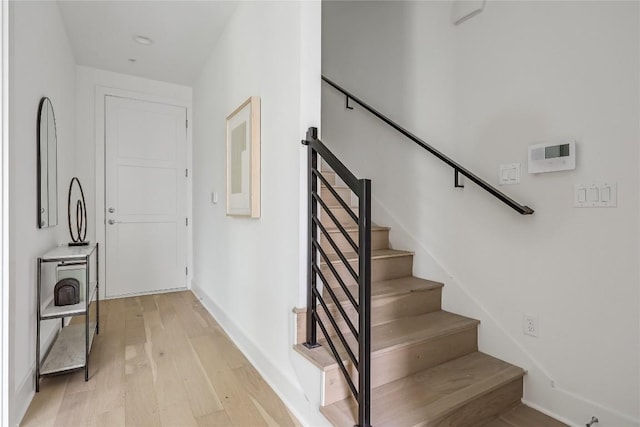 stairway with baseboards and hardwood / wood-style flooring
