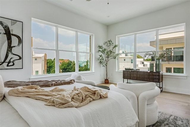 bedroom featuring baseboards, multiple windows, and wood finished floors